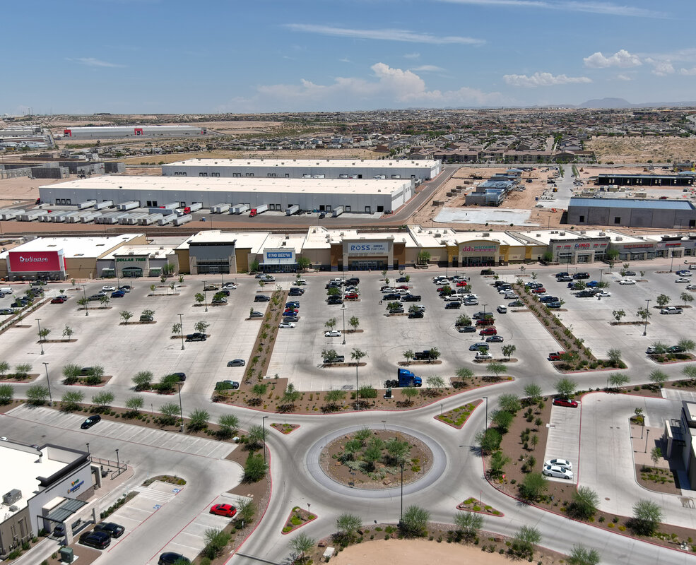 Aerial view of a retail center with paved parking areas and access roads.